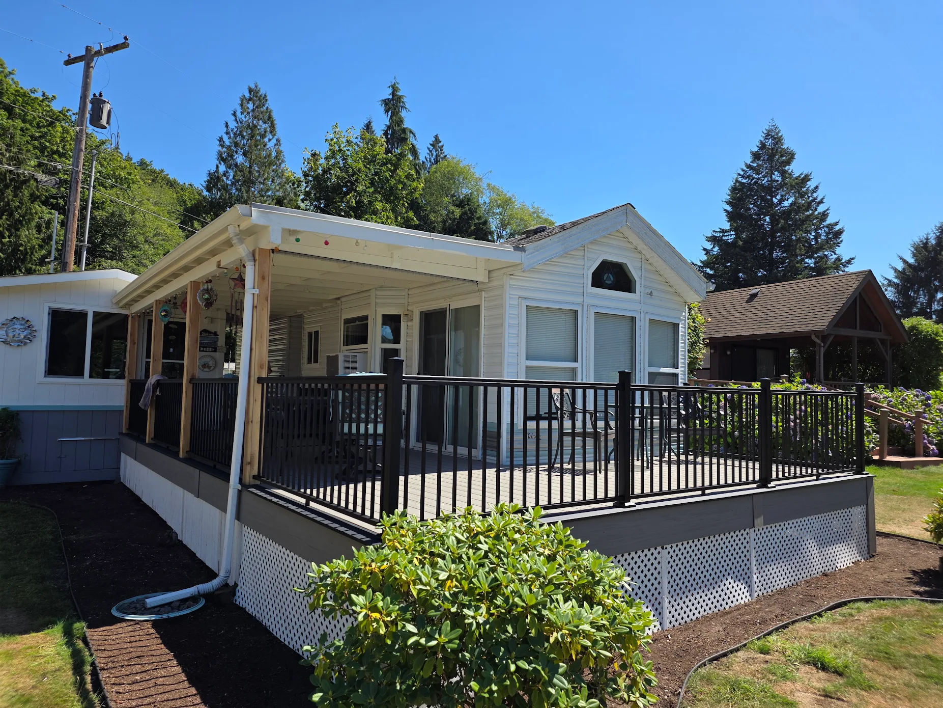 Black aluminum railing on a new composite deck built for a white mobile home.